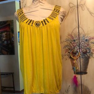 Yellow sleeveless shirt with embellishment around the neck.